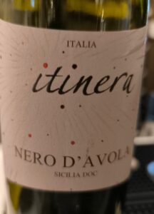 Flasche des Itinera Nero d'Avola Rotweins aus dunklem Glas mit einem eleganten, hellen Etikett.