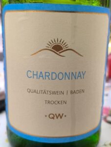 Klassische Weinflasche des QW Chardonnay Trocken Weißweins mit hellem Etikett und grünem Glas.